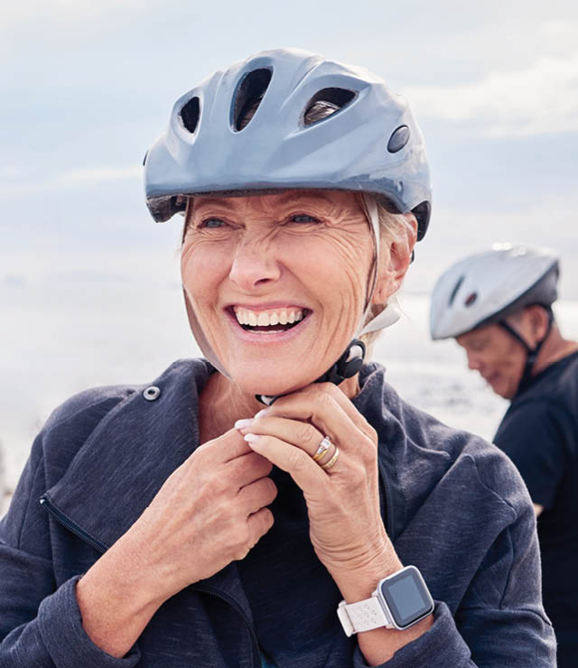 Nainen hymyilee ajaessaan ulkona polkupyörällä ja tuntee olonsa virkistyneeksi ja energiseksi rentouttavan yön jälkeen.